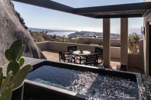 a view from the balcony of a house with a pool at Nimbus Santorini in Oia