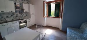 a kitchen with white cabinets and a table and a window at Casa Tua in Marina di Campo