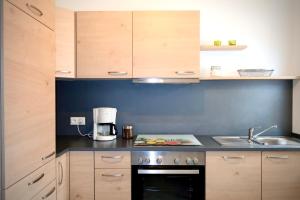 cocina con fregadero y fogones horno superior en Ferienwohnung Düsel, en Maroldsweisach