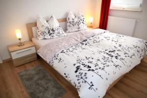 1 dormitorio con cama con sábanas y almohadas blancas y negras en Ferienwohnung Düsel, en Maroldsweisach