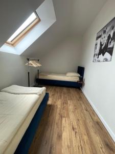 a bedroom with two beds and a wooden floor at Baltic House in Karwia