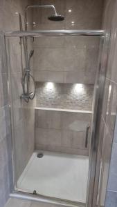 a shower with a glass door in a bathroom at Jasmin Apartments - Luxury 1 & 2 Bedroom units with Free Parking in Bushey