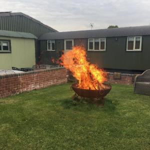 Un grande fuoco in un vaso in un giardino di Shepherds View at Oaks Barn Farm Alcester with optional paid for Hot tub 