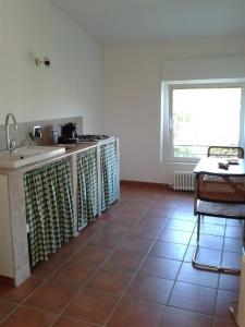 a kitchen with a tile floor and a sink at Casa Vacanze Giulienso in Ardea
