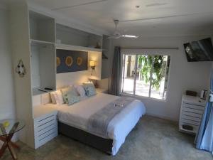 a bedroom with a large bed and a window at Bare Feet Retreat in Scottburgh +40 photos