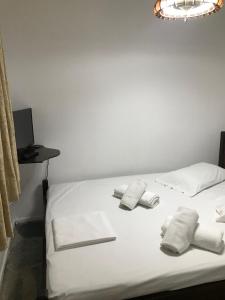 Un dormitorio con una cama blanca con toallas. en Bungalow - Camping Apollon, en Delfos
