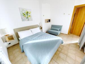 a bedroom with a bed and a blue chair at Profumo di Limoni Vacation Rental in Procida