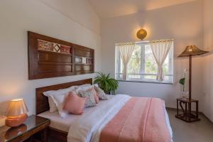 une chambre avec un grand lit et une fenêtre dans l'établissement El Cottage by StayVista - An enchanting escape with Scenic views, Colonial decor & Private plunge pool, à Lonavala 31 autres photos