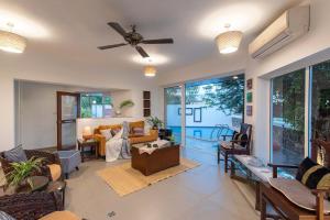 - un salon avec des canapés et un ventilateur de plafond dans l'établissement El Cottage by StayVista - An enchanting escape with Scenic views, Colonial decor & Private plunge pool, à Lonavala