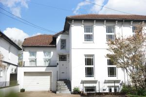 a white house with a garage at Stunning pied-a-terre moments from the water. in Netley