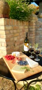a wooden cutting board with a bottle of wine and grapes at History House in Corfu