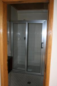a glass shower door in a bathroom with a tile floor at Jerusalem Hotel Lalibela in Lalibela