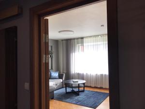 ein Wohnzimmer mit einem Sofa und einem Tisch in der Unterkunft Cosy Teika Apartment in Riga