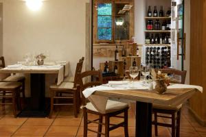una sala da pranzo con due tavoli e bottiglie di vino di Hotel Rezia a Bormio