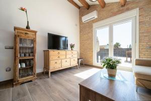 un soggiorno con TV e cassettiera in legno di Casa rural Maño a Deltebre