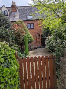 Granary Cottage في Mickleton: حاجز خشبي أمام المنزل