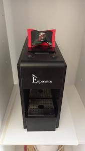 - une machine à expresso noire assise au-dessus d'une table dans l'établissement B&B La Reggia, à Venaria Reale