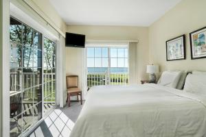 a bedroom with a large bed and a balcony at The Cliffside Resort Condominiums in Greenport