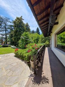 eine Veranda eines Hauses mit einer Bank und Blumen in der Unterkunft Villa Sarchi in Grantola