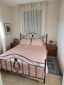 a bedroom with a bed with pink sheets and two night stands at Lovely Apartment with shalter room in Tel Aviv