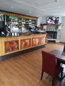 un bar dans un restaurant avec une table et des chaises dans l'établissement L'auberge des quatre routes, à Albussac