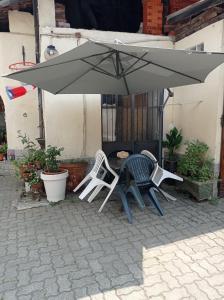 dwa krzesła i parasol na patio w obiekcie B&B La Reggia w mieście Venaria Reale