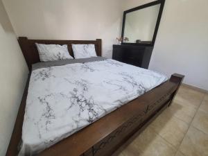 a bedroom with a bed with a wooden frame and a mirror at Lovely Apartment with shalter room in Tel Aviv