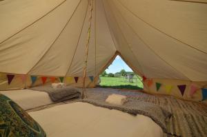 a canvas tent with two beds in a field at Starlight Glamping 