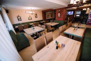 una vista aérea de un restaurante con mesas y sillas de madera en Pensiunea Bello en Marghita