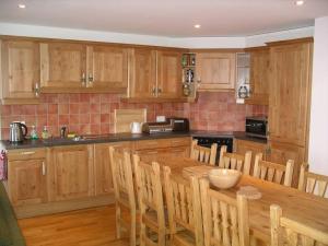 a kitchen with wooden cabinets and a wooden table at Résid. Les Esserts B40 in Champoussin