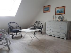 een kamer met 2 stoelen, een tafel en een dressoir bij macareux in Binic