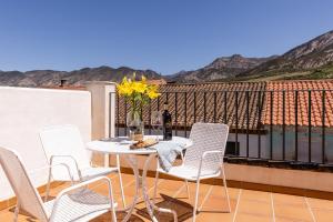 patio con mesa y sillas en el balcón en La Casa De Almocita, en Dúrcal