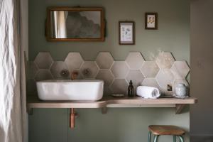 a bathroom with a sink and a mirror at Tomette Singulière in Château