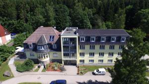 - une vue aérienne sur un grand bâtiment blanc dans l'établissement REGIOHOTEL Am Brocken Schierke, à Schierke