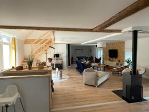 a living room with wooden floors and a living room with a couch at La grange in Orcival