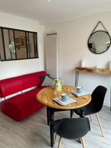 un soggiorno con divano rosso e tavolo di Superbe appartement, à proximité du centre d'Arles a Arles