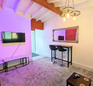 een woonkamer met paarse muren en een tv en een tafel bij kaoglen Wild-Hot tub-Cairngorms-Pet Friendly in Balnald