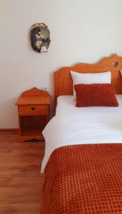 a bedroom with a bed with a wooden headboard and a table at Mosorel in Măgura