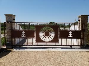 a gate with a wheel on top of it at Domaine du Soleil Couchant in Saintes-Maries-de-la-Mer