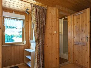 ein Bad mit Holzwänden, einem Fenster und einer Dusche in der Unterkunft Gartenhaus Haufe in Quedlinburg