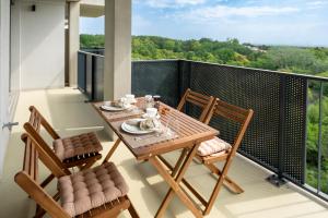 einen Tisch und Stühle auf einem Balkon mit Aussicht in der Unterkunft GRÜN & URBAN - direkt an der Therme - 15 Minuten ins Zentrum in Wien