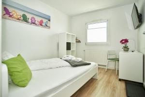 a white bedroom with a bed and a desk at Hotel City Inn in Magdeburg