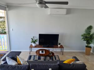 Alkion Villa في واجا واجا: غرفة معيشة مع أريكة زرقاء وتلفزيون