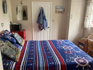 Un dormitorio con una cama con una manta de colores. en Cove Cott en Warsash