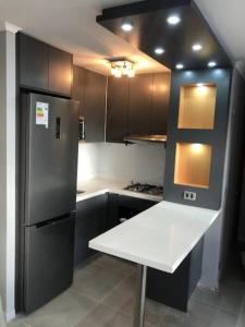 uma cozinha com um balcão branco e um frigorífico em Departamento en el Corazon de Providencia em Santiago