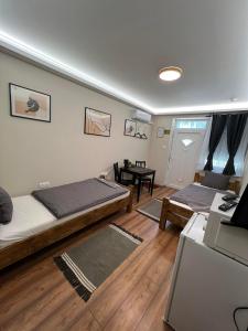 a living room with two beds and a table at Pálma Apartmanok Szálláshely Százhalombatta 4a in Százhalombatta