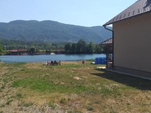 uma vista para um lago com uma mesa de piquenique e um edifício em Biser na Drini em Velika Reka