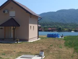 uma casa com um painel solar ao lado de uma massa de água em Biser na Drini em Velika Reka