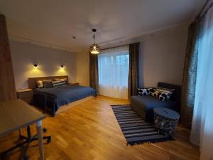 - une chambre avec 2 lits, un canapé et une fenêtre dans l'établissement Gelvadiskes Forest, à Vilnius