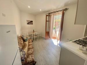 a kitchen with a couch and a table in a room at Appartamento Orchidea in Parghelia